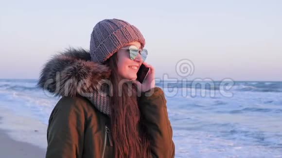 在海上度假时戴眼镜的女孩通过电话在户外交流视频的预览图