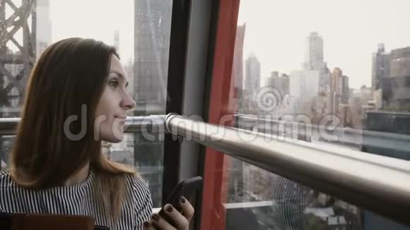 4K欧洲旅游女性在空中电车舱漂亮的女商人在纽约岛有智能手机视频的预览图
