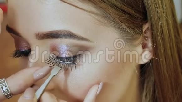 女孩化妆师为模特延伸睫毛建立起来视频的预览图
