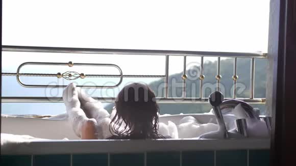 年轻女性沐浴后可以在泡沫浴缸中放松女孩享受热带度假胜地的水疗令人惊叹视频的预览图