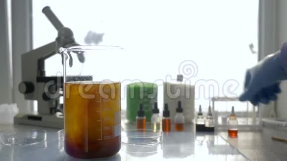 实验室经验无菌手套手工专业人员进行化学研究用大玻璃杯中的液体放在桌子上视频的预览图