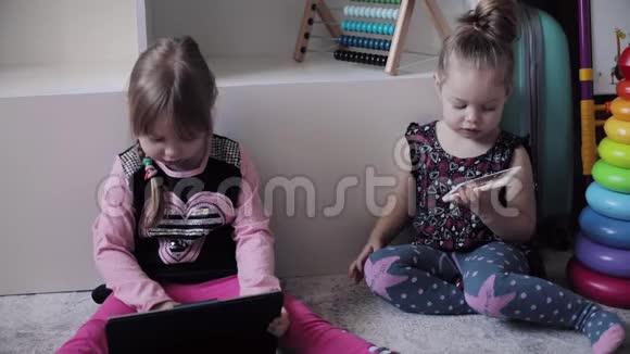 有趣的孩子坐在地板上使用电子设备视频的预览图