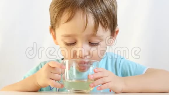 小男孩喜欢喝杯子特写的茶视频的预览图