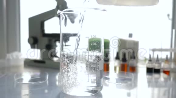 实验室工作化学家在自然光下将过滤过的水倒入实验室的玻璃特写视频的预览图