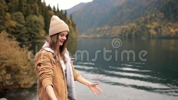 年轻时尚的白种人女性在山上的湖边玩她的边境牧羊犬旅费视频的预览图