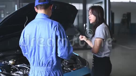 汽车技师与客户就汽车修理预算成本和保险进行了交谈亚洲女人视频的预览图