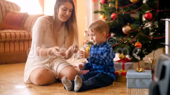 圣诞早晨小男孩和妈妈一起在客厅里扔彩纸开心地笑着视频的预览图