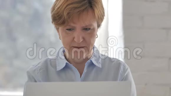 失落沮丧的老妇人在笔记本电脑上工作视频的预览图