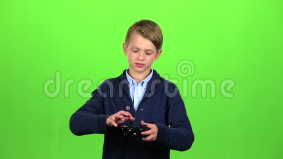 男孩在操纵杆上玩绿色屏幕慢动作视频的预览图