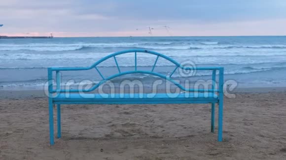 日落时沙滩上的蓝色长凳便利的基础设施可在海边放松海浪视频的预览图