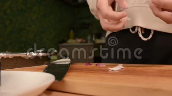 在厨房里一个女孩在一个木切割板上的特写压碎了诚实的牙齿来清洁它们家庭视频的预览图