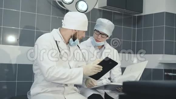 两名医生在诊所4K的平板电脑和笔记本上登记了一个数据视频的预览图