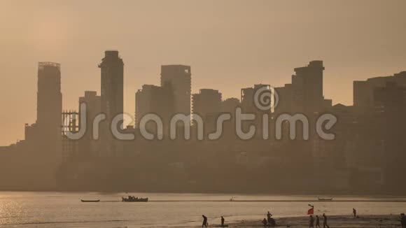 孟买摩天大楼背景下的日落从乔帕蒂海滩欣赏风景视频的预览图