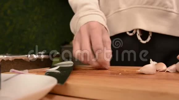 在厨房里一个女孩在一个木切割板上的特写压碎了诚实的牙齿来清洁它们家庭视频的预览图