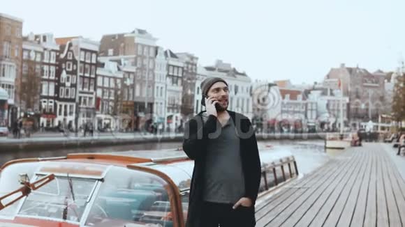 快乐的欧洲男人走着在电话里说话4K休闲创意胡子商人老城区河堤视频的预览图