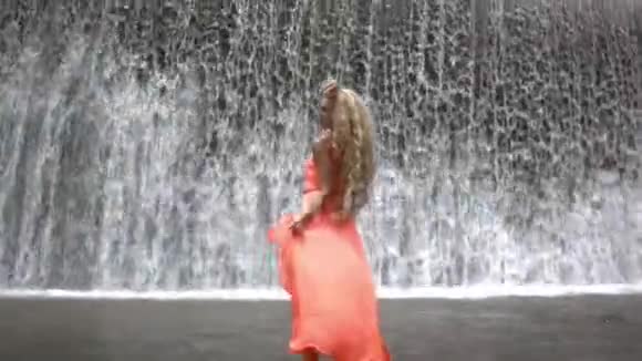 穿着橙色衣服摆姿势的年轻美女视频的预览图