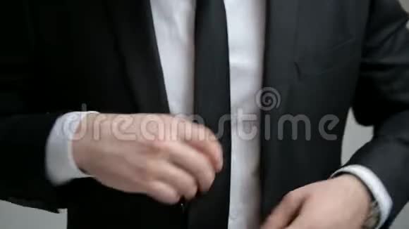 商人在他的黑色夹克上扣上纽扣视频的预览图