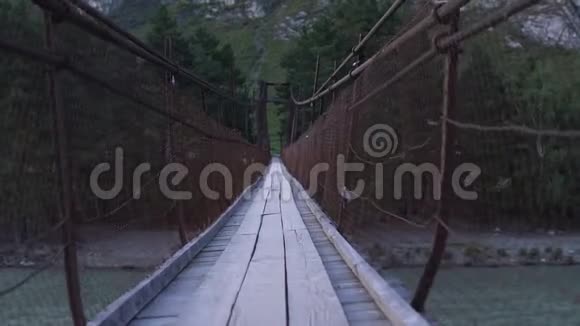 一个虚构的人物沿着摇摆的吊桥行走视频的预览图