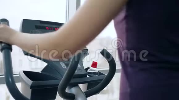 运动爱好女子靠窗在健身房从事运动模拟器视频的预览图