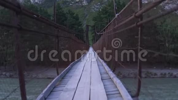 一个虚构的人物沿着摇摆的吊桥行走视频的预览图