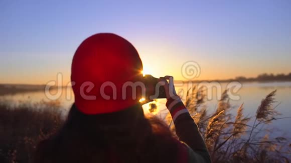 旅游少女旅行者女摄影师拍照少女拍海滩湖照片女人拍照视频的预览图