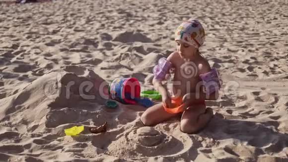 美丽的小女孩在4K的热带海滩上玩沙子视频的预览图