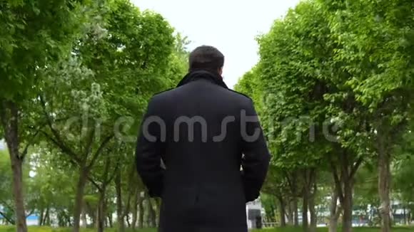 一个年轻人沿着公园的小巷散步视频的预览图