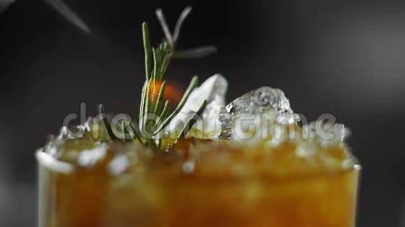冷的非酒精鸡尾酒柠檬迷迭香生姜和克瓦斯在一个充满冰的粉碎点燃迷迭香视频的预览图