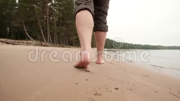 白种人的腿在近水的沙滩上视频的预览图