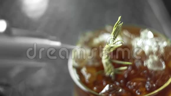 冷的非酒精鸡尾酒柠檬迷迭香生姜和克瓦斯在一个充满冰的粉碎点燃迷迭香视频的预览图