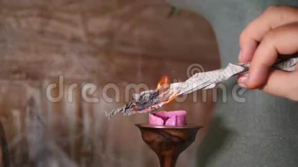 人类在冥想瑜伽练习前用纸烧蜡烛4K慢动作视频的预览图