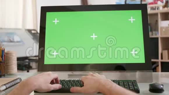 男性手在绿色屏幕前的键盘上打字视频的预览图