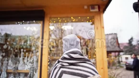 在圣诞节和新年期间女人正步行去一家有圣诞装饰的商店视频的预览图