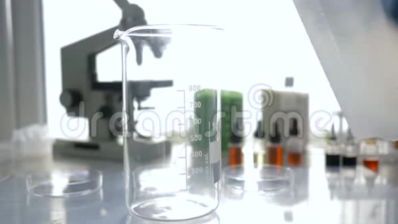 实验室医学科学研究员将过滤过的水在自然光下倒入实验室的玻璃特写视频的预览图