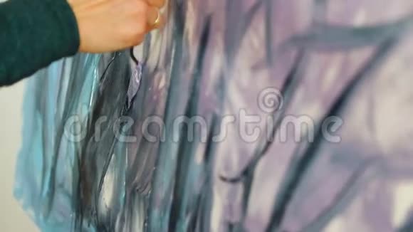 用刮刀和丙烯酸涂料绘图一位女艺术家的手手里拿着一把铲子用于绘画和绘画视频的预览图