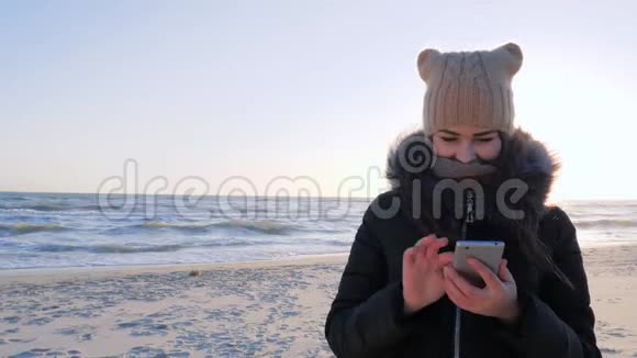 在海滩上使用手机上网的妇女视频的预览图