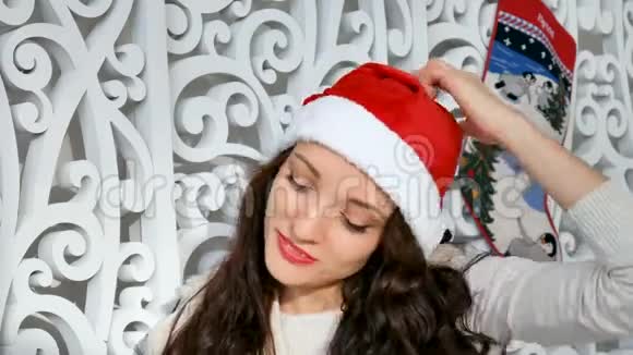节日和人的概念美丽的女人戴着圣诞帽和卷发在背景下微笑视频的预览图