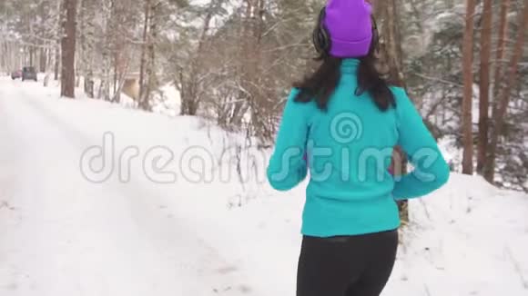 戴耳机的女孩慢跑冬季后景视频的预览图