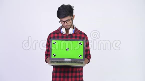 年轻的留着胡子的印度时髦男人带着笔记本电脑视频的预览图