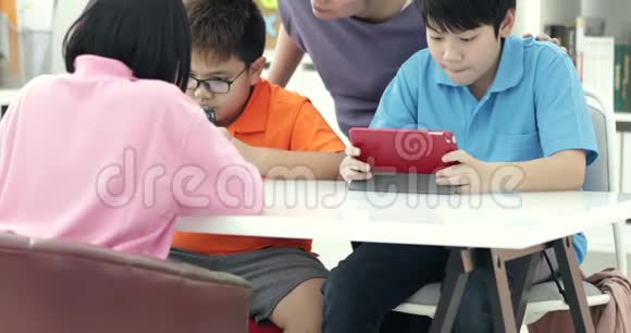 亚洲老师和三个孩子用数字标签娱乐自己视频的预览图