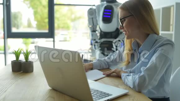 女办公室工作人员一边打字一边和机器人说话视频的预览图