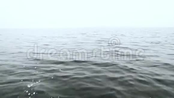 阴天时一艘快速航行的船在海上溅起水花视频的预览图
