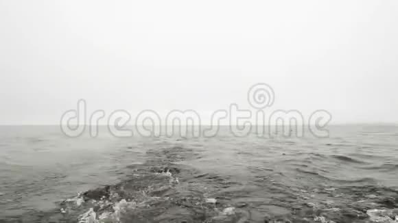 阴天时一艘快速航行的船在海上溅起水花视频的预览图