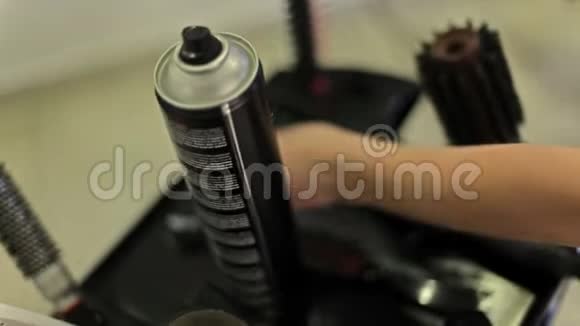 理发师从一张桌子上拿出一个头发喷雾剂上面有梳子卷发熨斗和其他理发和造型用品视频的预览图