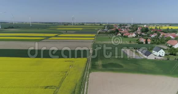 春日风力涡轮机和农田在村庄附近缓慢移动视频的预览图