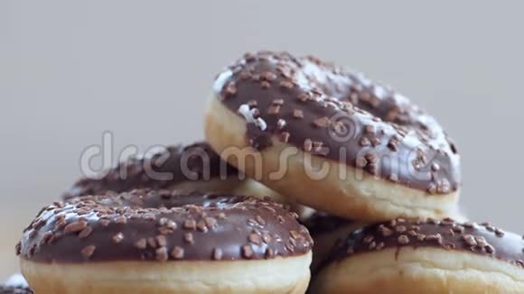 高卡路里甜美味的甜甜甜圈与巧克力糖霜在盘子上关闭视频的预览图