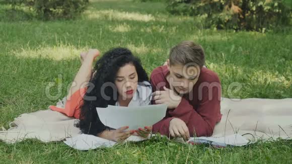 两名年轻学生正在阅读概要准备在夏季公园参加考试视频的预览图