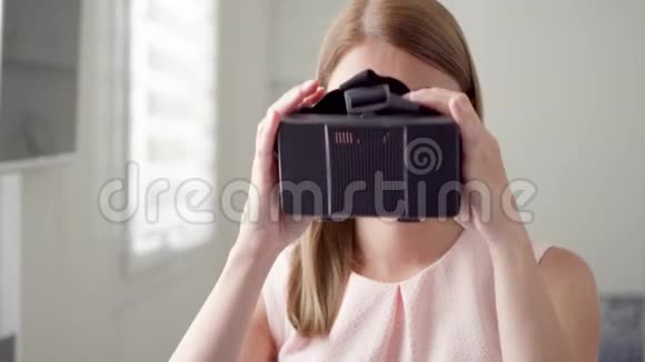 年轻女性在家使用VR虚拟现实360眼镜进行浏览缩放和点击手势视频的预览图