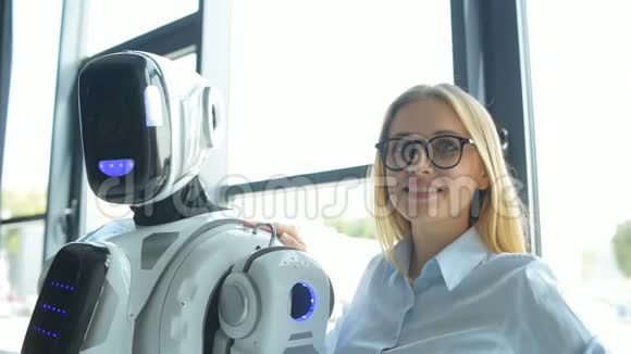 自信的上班族抚摸着机器人的肩膀微笑着视频的预览图