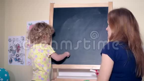 母亲和女儿用黑板上的粉笔给母亲写字视频的预览图